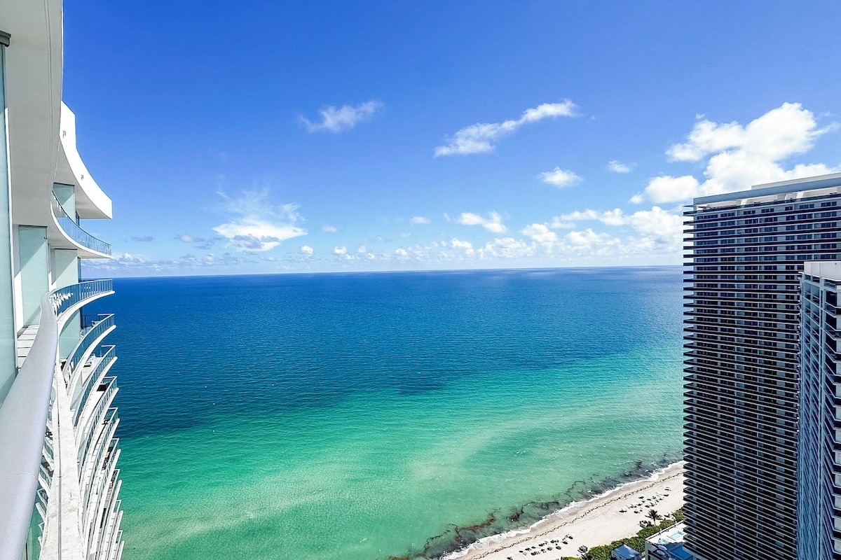 A high-rise building with a view of the ocean and a beach.