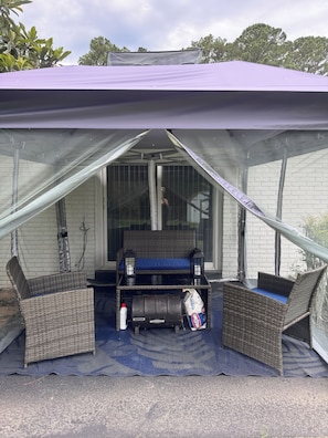 A covered outdoor seating area with wicker furniture and a blue mat. - Welcome to your modern, cozy, family-friendly home away from home in Savannah,Ga (Savannah)