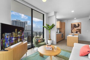 A modern apartment with a city view, a flat-screen TV, a dining area, and a kitchen. - The Crosby Miami Worldcenter (Miami)