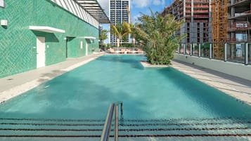 Una piscina al aire libre, sillones reclinables de piscina