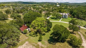 A rural property with a main house, a smaller building, and a large tree. - An 1849 farmhouse that traveled 1,200 miles (Fredericksburg)