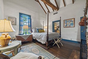 Une chambre à coucher de style traditionnel, avec un lit à baldaquin, un plafond en bois et une décoration rustique.