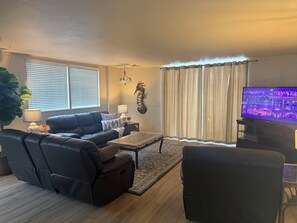 A living room with a sofa, coffee table, and television. - Oceanfront Paradise in Madeira Beach. Private Balcony. Pool & Hot Tub (Madeira Beach)