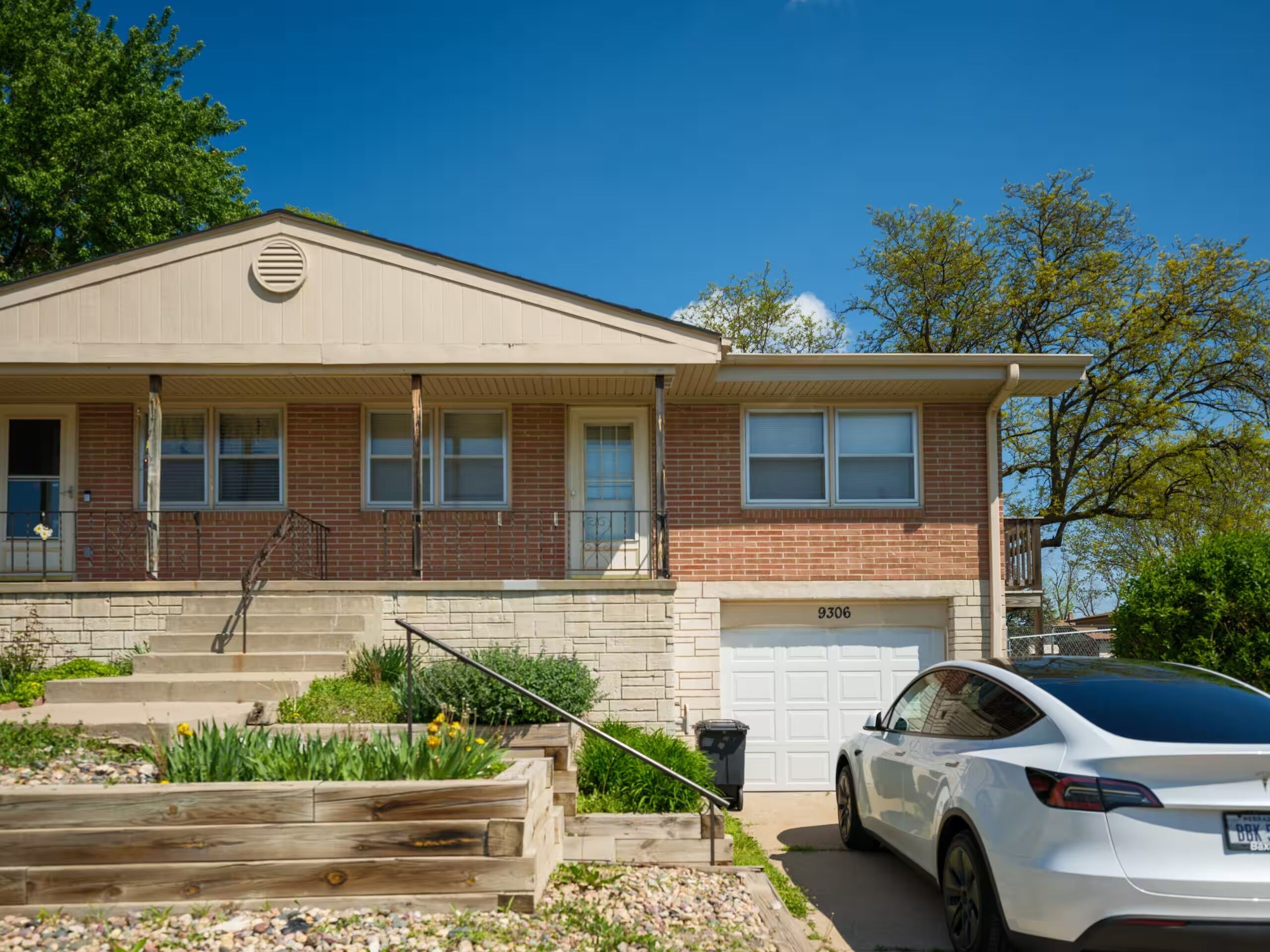 A two-story house with a garage, a front porch, and a driveway.