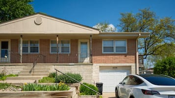 A two-story house with a garage, a front porch, and a driveway.