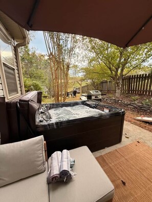 A hot tub with a view of a backyard, a covered seating area, and a patio. - Dog-Friendly Mountain Home w/ Hot Tub & Rec Room (Asheville)
