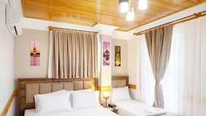 A hotel room with two beds, a wooden ceiling, and a view of the cityscape. - Home Quality Hotel (Istanbul)