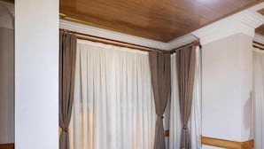 A room with a beige sofa, wooden flooring, and curtains. - Home Quality Hotel (Istanbul)