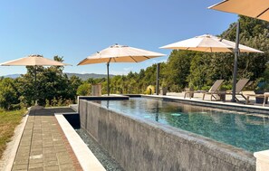 A pool area with lounge chairs and umbrellas. - Amazing home in Novi Marof - Kljuc with sauna (Novi Marof - Kljuc)