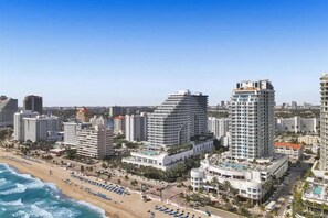 A coastal cityscape with high-rise hotels, a beach, and a clear sky.