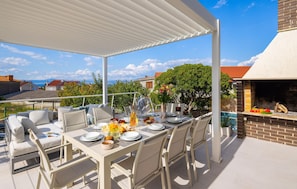 An outdoor patio with a table set for dining, surrounded by chairs, and a barbecue grill. - Stunning home in Supetar with private swimming pool, can be inside or outside (Supetar)