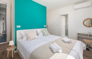 Ein Hotelzimmer mit Bett, Nachttisch, Stuhl, Badezimmer und Spiegel.