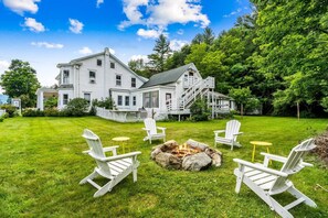 A large house with a fire pit and outdoor seating.