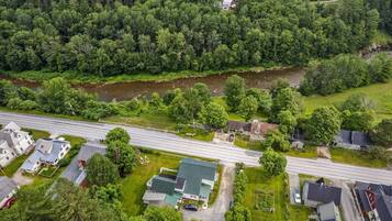 An aerial view of a residential area with houses, a road, and a river.