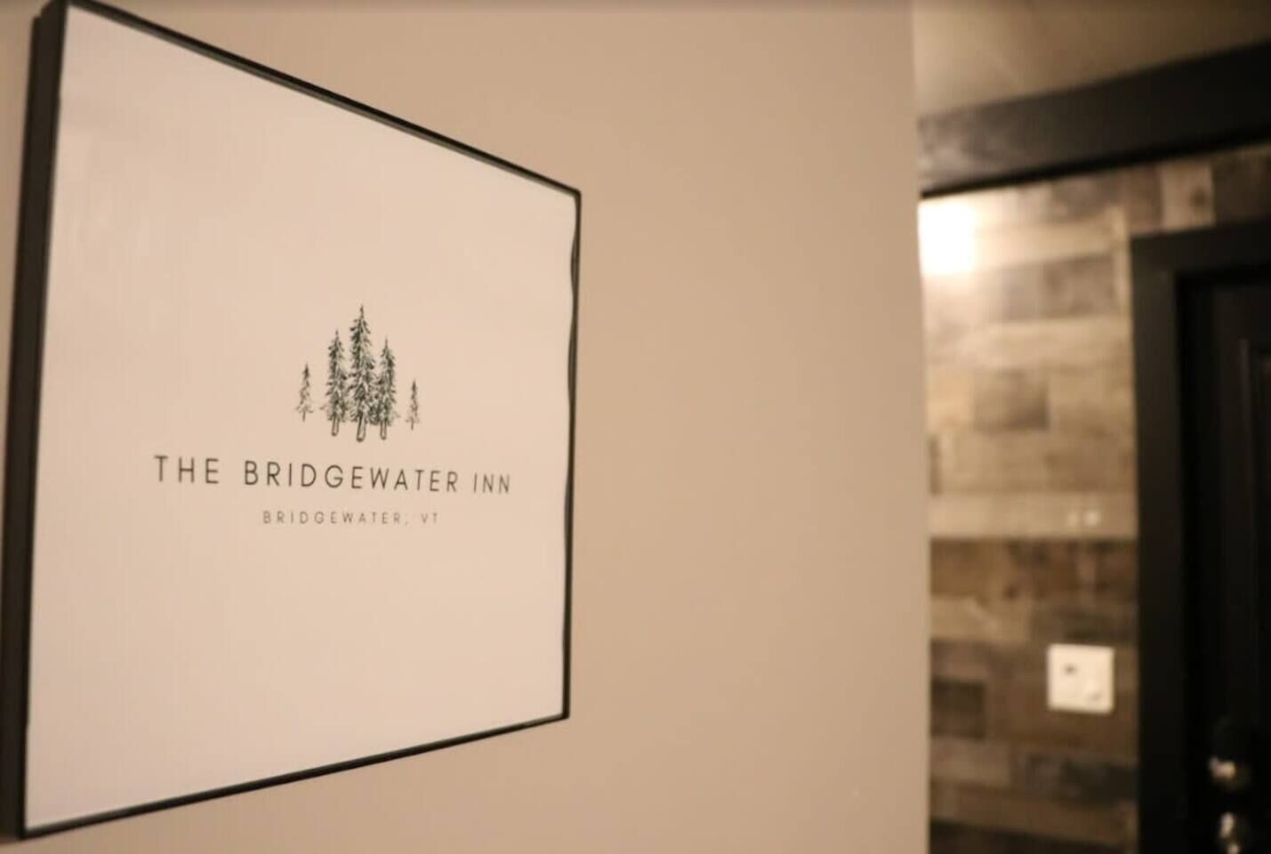 A framed sign for The Bridgwater Inn with a simple logo of trees and the inn's name.