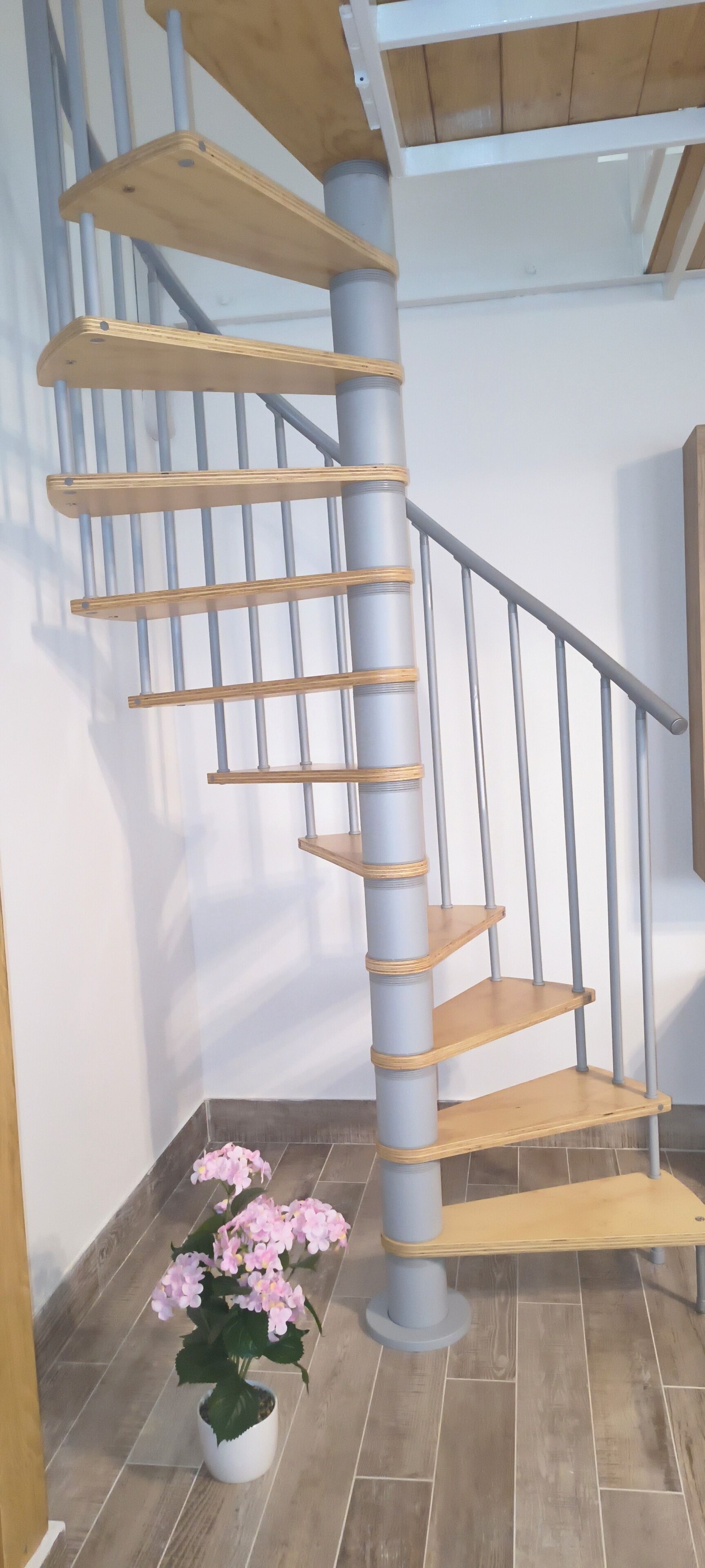A spiral staircase with wooden steps and metal railings.