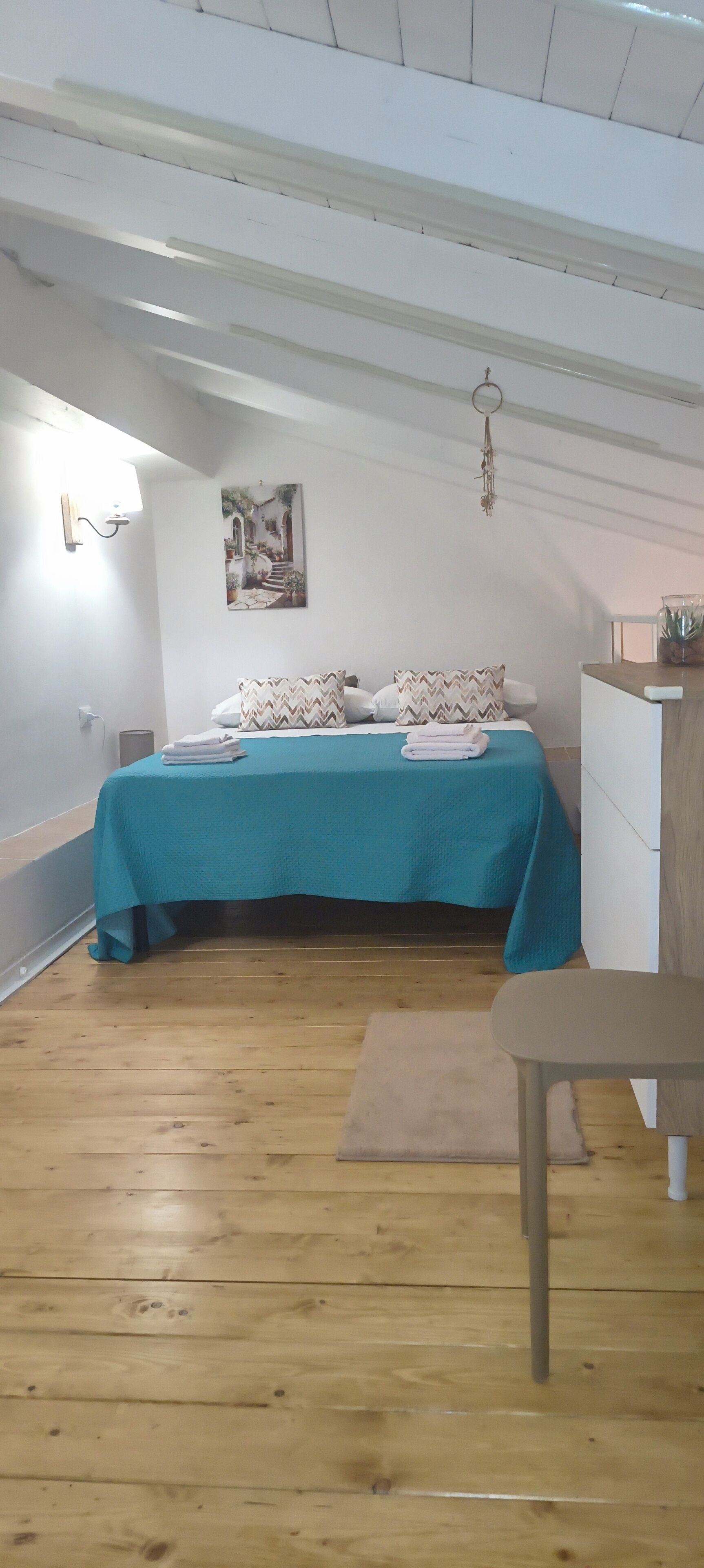 Un dormitorio con cama, escritorio y silla.