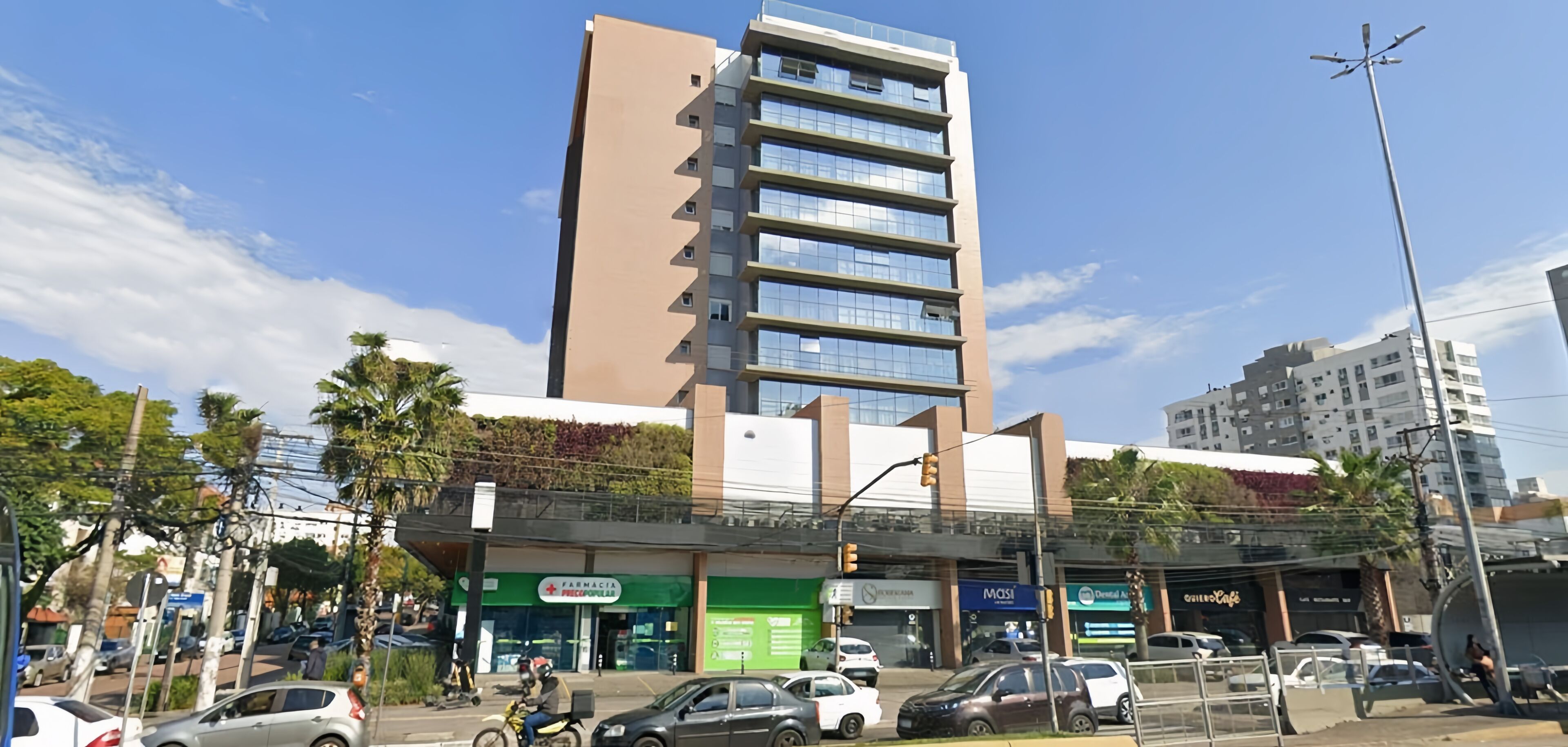 Un edificio de varios pisos con diseño moderno, que presenta un amplio frente de cristal y un techo plano.