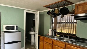 Uma cozinha compacta com micro-ondas, pia e armários de madeira.