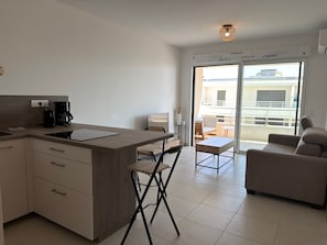 Eine moderne Küche mit Einbauherd, Kaffeemaschine und einem Essbereich mit Tisch und Stühlen.