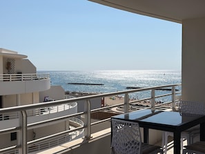 A balcony with a view of the sea, a table, and chairs. - Archipel Panarea vue mer · Valras'Loc (Valras-Plage)