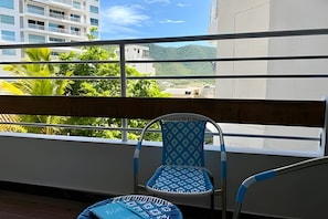 Ein Balkon mit Blick auf ein Gebäude und Grünflächen.