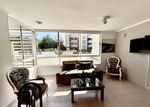 A modern living room with a sofa, chairs, a coffee table, and a TV. - Enjoy Rodadero 1 Block to Beach | 3BR 3BA Fits 10 (Santa Marta)