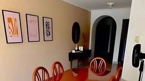 A dining area with a wooden table and chairs, framed artwork on the wall, and a mirror. - Enjoy Rodadero 1 Block to Beach | 3BR 3BA Fits 10 (Santa Marta)