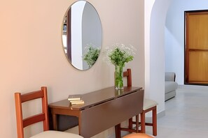 A room with a desk, chairs, a mirror, and a vase with flowers. - Enjoy Rodadero 1 Block to Beach | 3BR 3BA Fits 10 (Santa Marta)