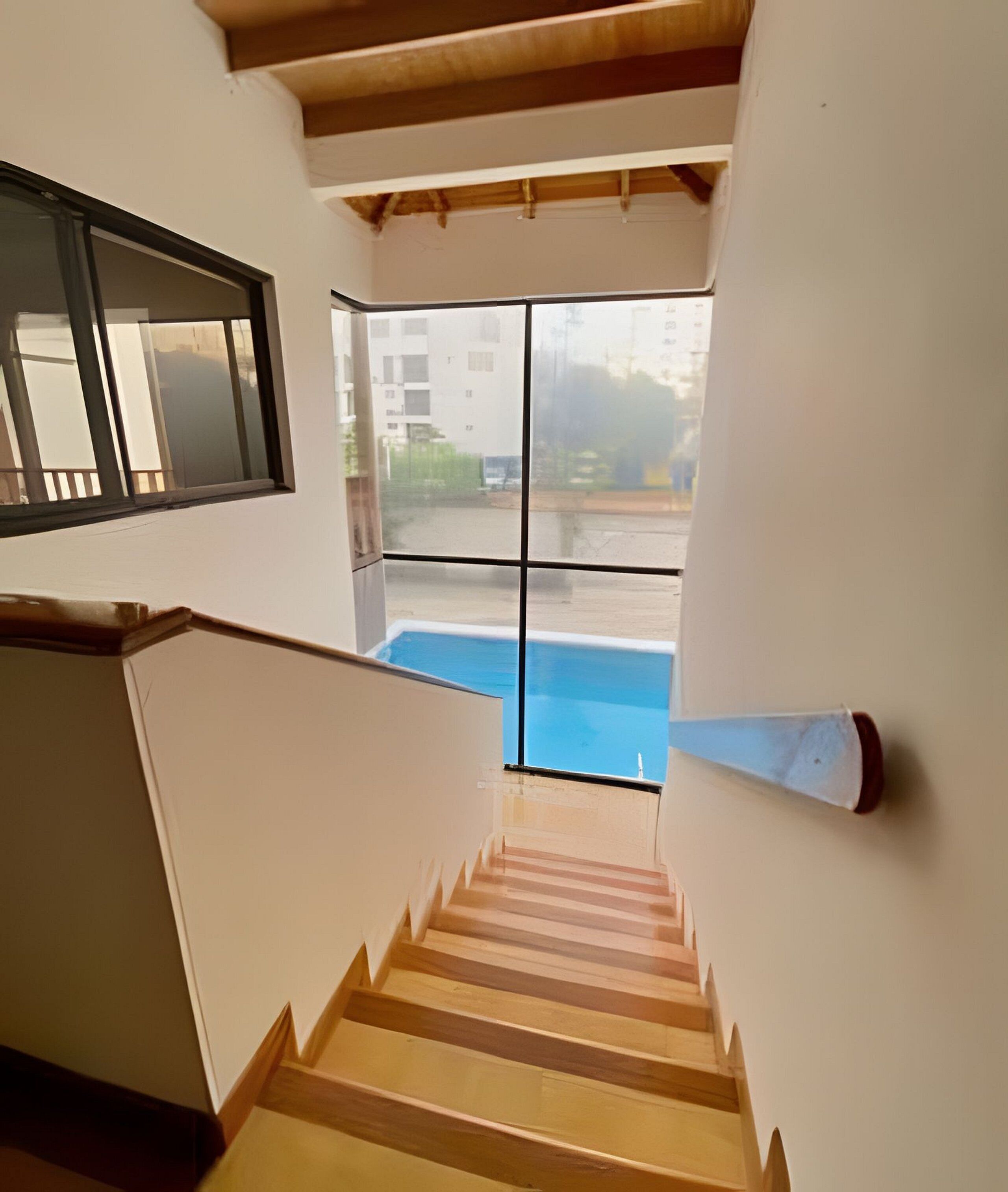 Eine Treppe führt zu einem Balkon mit Blick auf einen Pool.