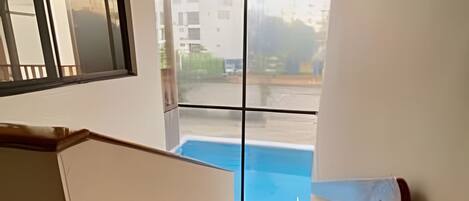 A staircase leading to a balcony with a pool view.