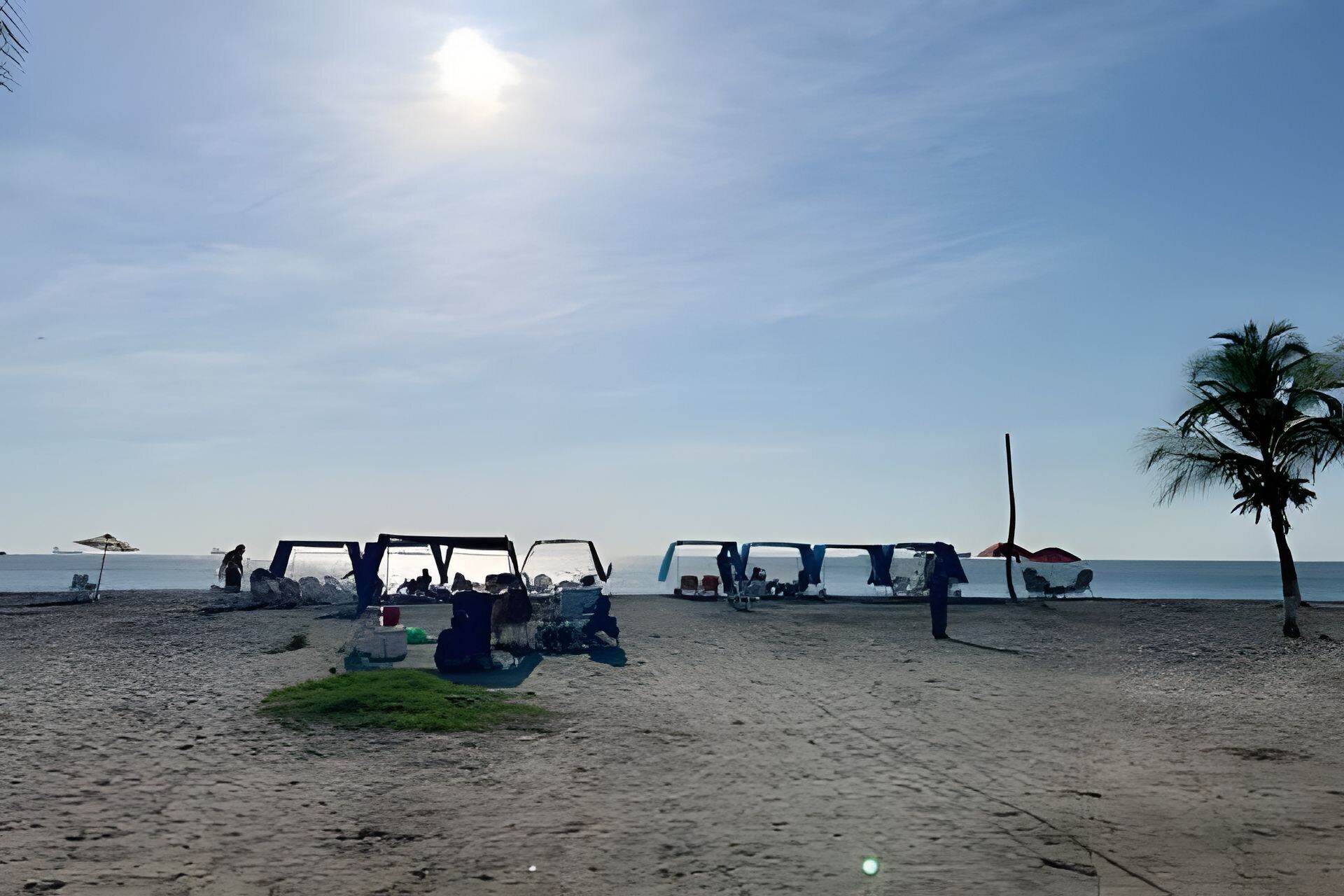 A beach with sun umbrellas and lounge chairs.