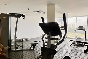 A gym with exercise equipment, including a treadmill and an elliptical machine. - Bello Horizonte Haven | Resort Pools & Beach (Santa Marta)