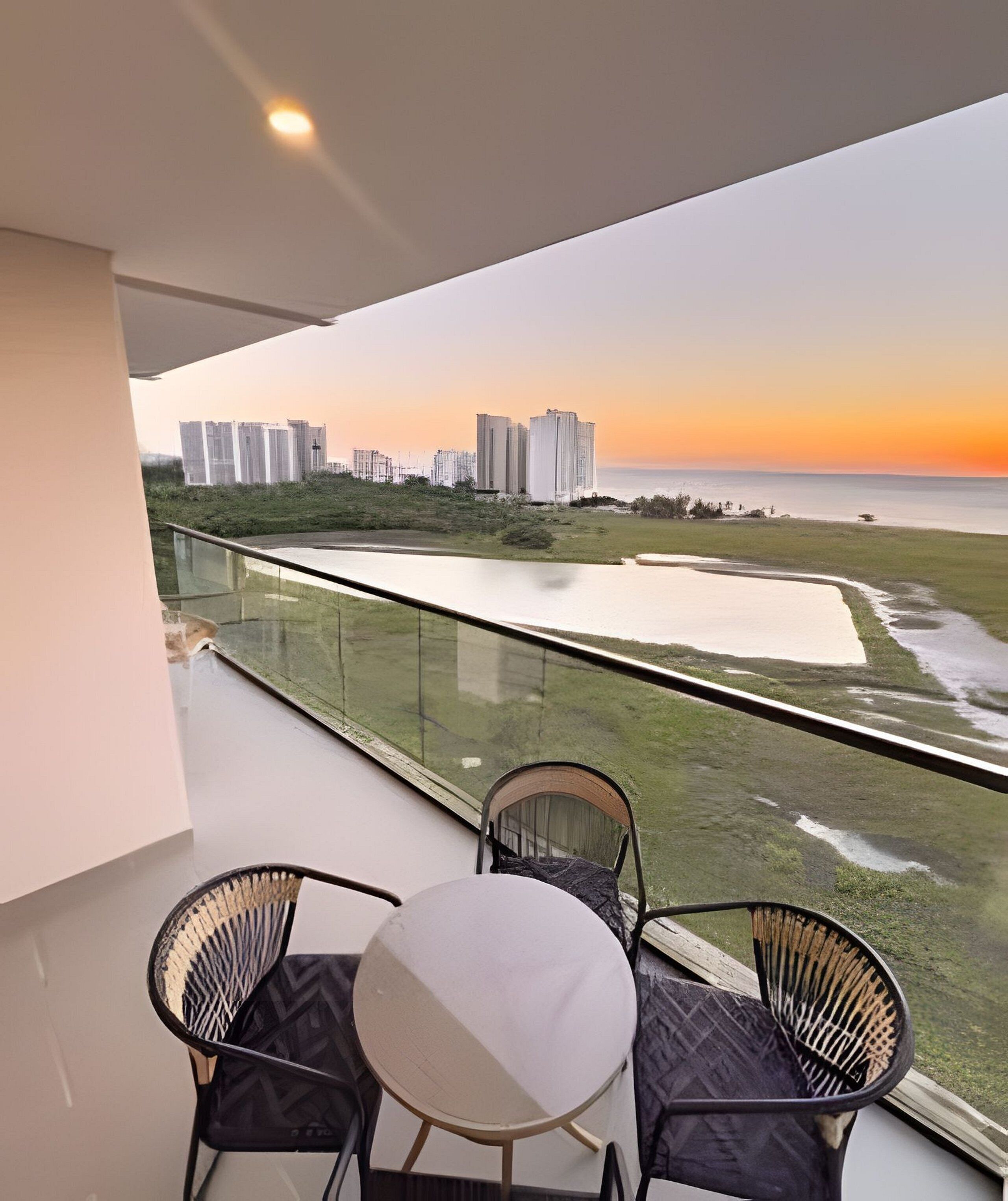 Uma varanda com vista para a praia e edifícios altos.