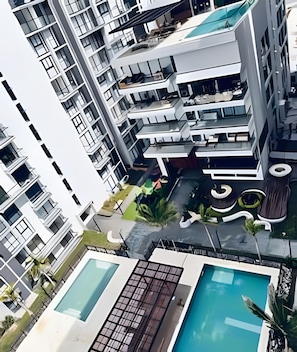 A modern multi-story building with balconies, a rooftop pool area, and a landscaped garden. - Ocean view, swimming pools, gym, and beach access (Santa Marta)