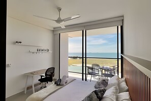 A bedroom with a bed, a desk, a chair, and a view of the beach. - Ocean view, swimming pools, gym, and beach access (Santa Marta)