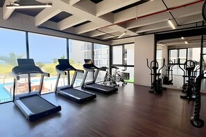 A gym with treadmills, stationary bikes, and weight machines. - Ocean view, swimming pools, gym, and beach access (Santa Marta)