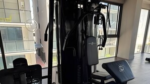 Et fitnesscenter med bænkpres, squat stativ og kabelmaskine.