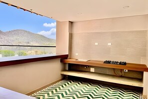 Eine kleine, moderne Küche mit Blick auf eine gebirgige Landschaft.