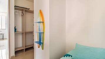 A bedroom with a bed, a closet, and a wall-mounted shelf with a colorful object.