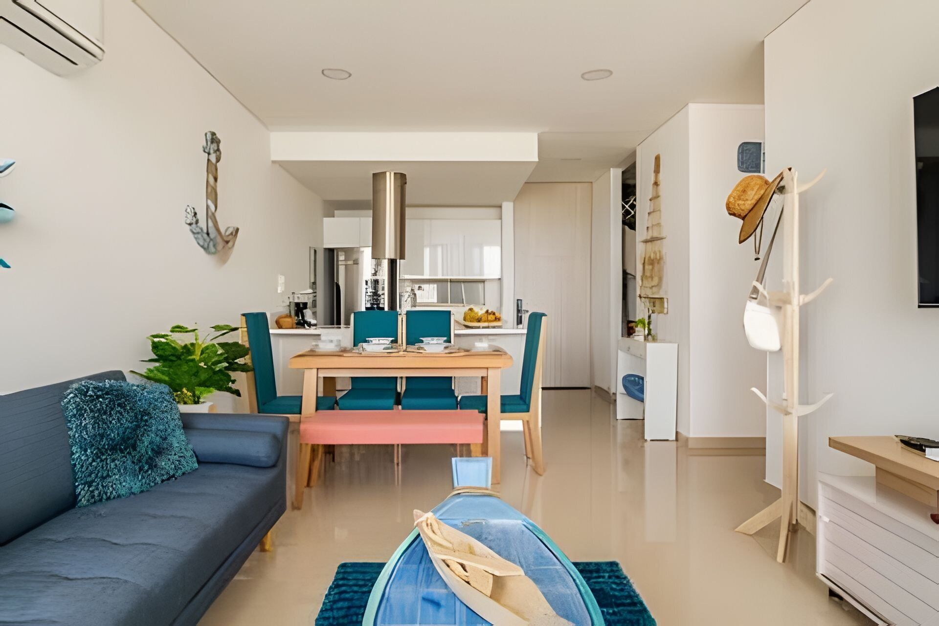 A modern living room with a sofa, a dining table with chairs, and a kitchen in the background.