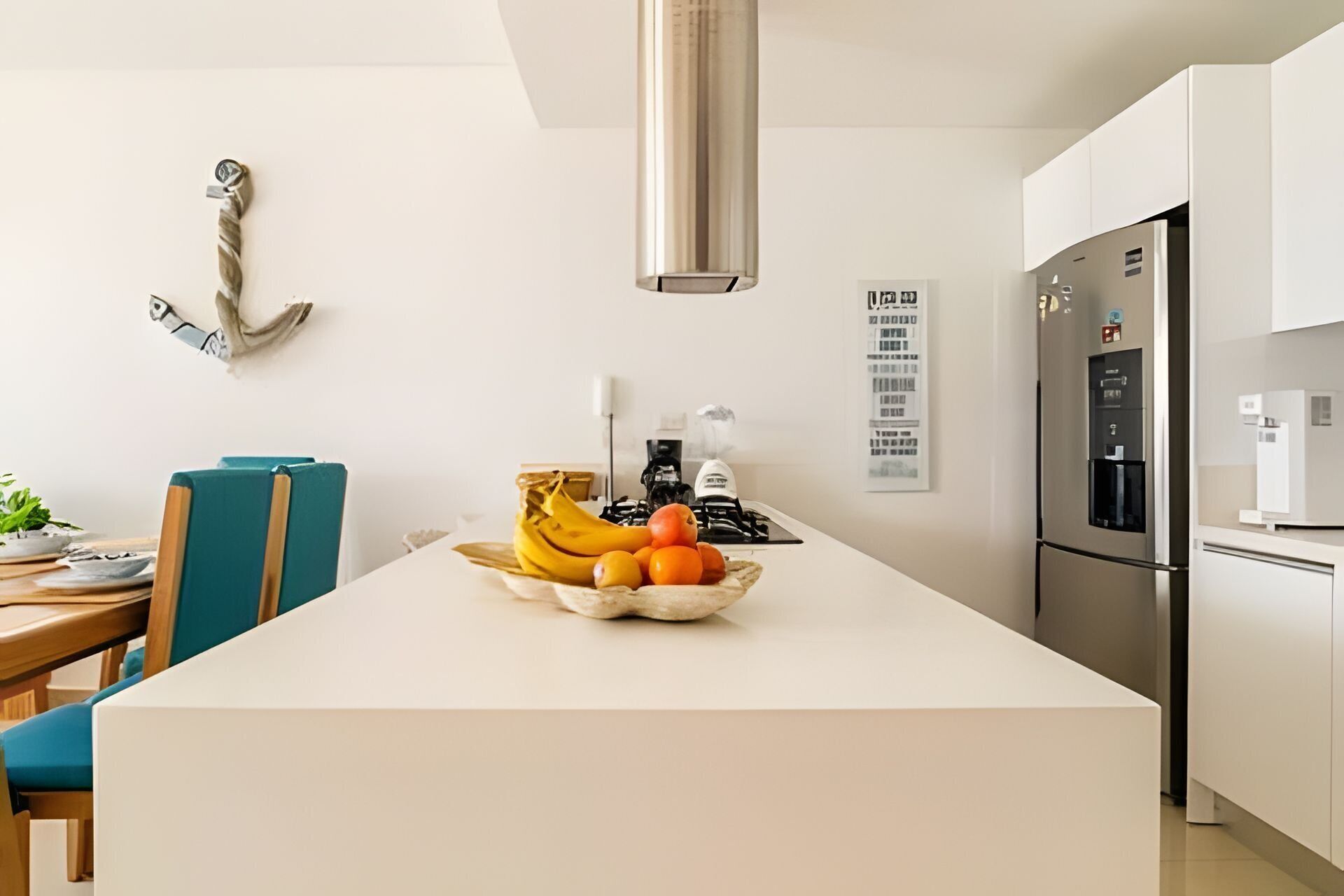 Une cuisine moderne dotée d’un îlot central, d’appareils électroménagers en acier inoxydable et d’un coin repas avec une table et des chaises.