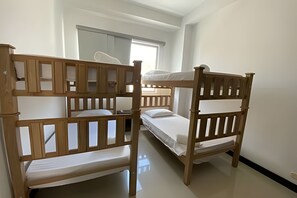 A room with bunk beds, a window with curtains, and a mirror on the wall. - Rodadero Escape | Pool, Balcony, BBQ & Parking (Santa Marta)