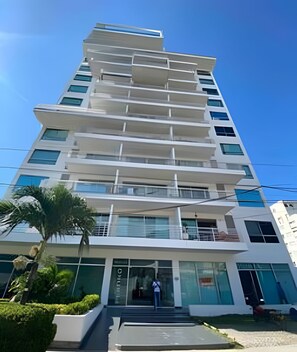 A multi-story building with a modern architectural design, featuring a series of balconies and large windows. - Rodadero Escape | Pool, Balcony, BBQ & Parking (Santa Marta)