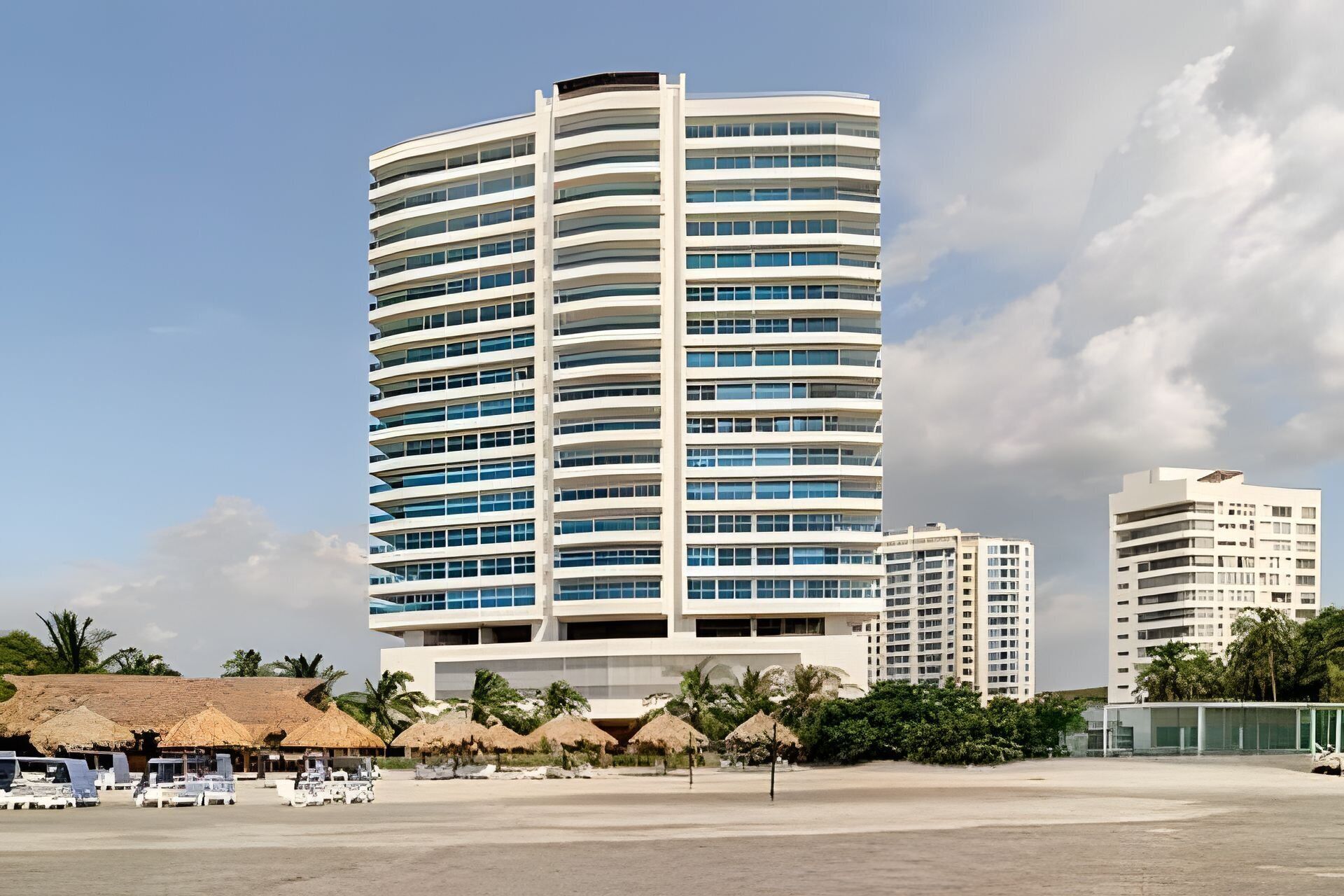 A multi-story hotel with a curved facade, large windows, and a flat roof.