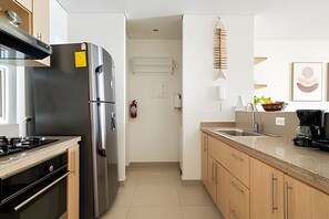 Eine moderne Küche mit Edelstahlgeräten, Holzschränken und Fliesenboden.