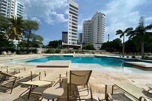 A swimming pool area with lounge chairs and a view of high-rise buildings. - Exclusive Ocean View | Playa Salguero • Sky Club (Gaira)