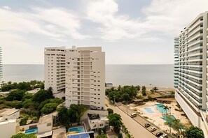 Un immeuble de grande hauteur doté de nombreux balcons, d’une piscine et offrant une vue sur la mer.