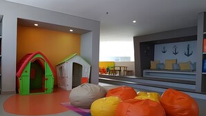 Ein Kinderspielbereich mit einem Spielhäuschen und Sitzsäcken.