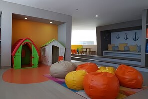Ein Kinderspielbereich mit einem Spielhäuschen und Sitzsäcken.